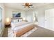 Light and airy bedroom featuring a ceiling fan, carpet flooring, and a doorway to the bathroom at 240 Whispering Pines Way, Davenport, FL 33837