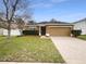 Charming one-story home featuring manicured landscaping and a brick paver driveway at 240 Whispering Pines Way, Davenport, FL 33837