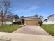 Charming one-story home featuring manicured landscaping and a brick paver driveway at 240 Whispering Pines Way, Davenport, FL 33837