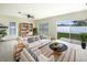 Bright living room with a ceiling fan, shelving, and a sliding glass door to the backyard at 240 Whispering Pines Way, Davenport, FL 33837