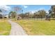 Outdoor basketball court with black fencing is surrounded by green space and mature trees at 2865 Eastham Ln, Kissimmee, FL 34741