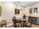 Elegant dining room featuring a glass table, chandelier, and ornate art pieces on the wall at 2865 Eastham Ln, Kissimmee, FL 34741