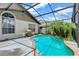 Backyard pool with a screened enclosure, concrete patio, and surrounding tropical foliage at 3221 White Dove Ln, Kissimmee, FL 34746