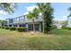 Exterior view of townhome featuring screened patios and grassy area, and mature landscaping at 3575 Victoria Pines Dr # 276, Orlando, FL 32829