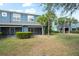 Townhome backyard showcasing screened lanai, vibrant green grass and several palm trees at 3575 Victoria Pines Dr # 276, Orlando, FL 32829