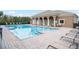 Community pool with lounge chairs and building with pillars on a sunny day at 3575 Victoria Pines Dr # 276, Orlando, FL 32829