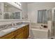 Bathroom featuring a granite double sink vanity and a tiled shower and tub at 372 Aylesbury Ct, Kissimmee, FL 34758