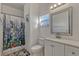 Bright bathroom featuring a vanity with a modern sink, framed mirror, toilet and a shower/tub combo with a colorful curtain at 372 Aylesbury Ct, Kissimmee, FL 34758