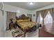 Bedroom featuring an ornate wooden bed frame, neutral walls, and matching side tables at 372 Aylesbury Ct, Kissimmee, FL 34758