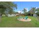 Backyard featuring green grass, a deck, landscaping and a fire pit area with Adirondack chairs at 4216 Kildaire Ave, Orlando, FL 32812