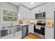 Updated kitchen featuring a stainless steel sink, appliances, and white cabinetry at 4216 Kildaire Ave, Orlando, FL 32812