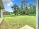 View of the expansive, grassy backyard bordered by lush trees and surrounding homes at 4790 Sw 166Th Loop, Ocala, FL 34473