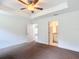 Comfortable bedroom featuring tray ceiling, neutral carpet flooring, closet and ensuite access at 4790 Sw 166Th Loop, Ocala, FL 34473