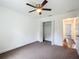 Comfortable bedroom featuring neutral carpet flooring, closet, ceiling fan, and ensuite access at 4790 Sw 166Th Loop, Ocala, FL 34473