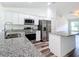 Modern kitchen boasts white cabinetry, stainless appliances, and granite countertops at 4790 Sw 166Th Loop, Ocala, FL 34473