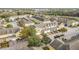 An aerial view showcases a well-maintained residential area with colorful townhouses, trees, and paved roads at 4820 Battaglia Blvd, St Cloud, FL 34769
