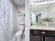Well-lit bathroom featuring a granite countertop, dark cabinets, and decorative shelves for a clean, modern aesthetic at 4820 Battaglia Blvd, St Cloud, FL 34769