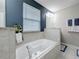 A luxurious bathtub is surrounded by tile and a blue accent wall, and a window at 4820 Battaglia Blvd, St Cloud, FL 34769