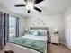 Cozy bedroom featuring soft carpet, a cushioned headboard, floral decor, and natural light from the window at 4820 Battaglia Blvd, St Cloud, FL 34769