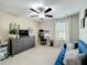 Comfortable bedroom with a blue sofa, desk, and modern ceiling fan, perfect for relaxation and productivity at 4820 Battaglia Blvd, St Cloud, FL 34769