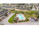 Aerial view of a refreshing community pool surrounded by palm trees, with ample seating and a cabana at 4820 Battaglia Blvd, St Cloud, FL 34769