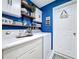 Charming laundry room with bright blue walls, floating shelves, and modern washer and dryer units at 4820 Battaglia Blvd, St Cloud, FL 34769