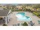 Aerial view of community pool with a cabana, tables, chairs, lounge chairs and lush landscaping at 4820 Battaglia Blvd, St Cloud, FL 34769