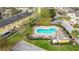 Aerial view of community pool with palm trees, picnic tables, and lush landscaping in a townhome community at 4820 Battaglia Blvd, St Cloud, FL 34769