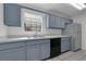 Bright kitchen featuring blue cabinets, a stainless steel refrigerator, and modern appliances at 486 Abba St, Altamonte Springs, FL 32714