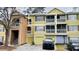 Front exterior of a yellow two-story apartment building with a black truck in the driveway at 5017 City St # 1932, Orlando, FL 32839