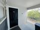 Condo entrance featuring a black front door, unit number, and outdoor patio area with wooded views at 5017 City St # 1932, Orlando, FL 32839