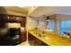 Well-lit kitchen with dark cabinets and shining granite countertop at 5017 City St # 1932, Orlando, FL 32839
