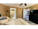 Well-lit bedroom with ceiling fan, en-suite bathroom, and TV at 5017 City St # 1932, Orlando, FL 32839