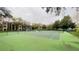 Tennis court with green surface, surrounded by trees at 5017 City St # 1932, Orlando, FL 32839