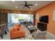 Vibrant living room with an orange couch, patterned chairs, and a large window view of the pool at 510 Captiva Dr, Davenport, FL 33896