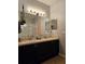 Bathroom with double sinks, black cabinetry, gold fixtures, and a large mirror with modern lighting at 554 Pinebranch Cir, Winter Springs, FL 32708