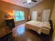 This bedroom features wood floors, a ceiling fan, and a window that lets in natural light at 554 Pinebranch Cir, Winter Springs, FL 32708