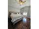 Cozy bedroom with a king-size bed, dark wood floors, a ceiling fan, and natural light from the window at 554 Pinebranch Cir, Winter Springs, FL 32708