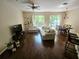 Sunlit living room with hardwood floors, plush sofa, and sliding glass doors to the outside at 554 Pinebranch Cir, Winter Springs, FL 32708