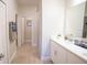 Bright bathroom featuring a large mirror, white cabinets, and modern fixtures with wood look tile floors at 5591 Maddie Dr, Haines City, FL 33844