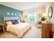 Bright bedroom featuring a large window, neutral carpet, and a calming blue accent wall at 5591 Maddie Dr, Haines City, FL 33844