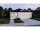 New home with a two-car garage, well-kept landscaping, and inviting curb appeal at 5591 Maddie Dr, Haines City, FL 33844