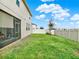 Well-maintained backyard featuring green grass, a white fence, and a partial view of the screened lanai attached to the house at 565 Big Pine Ave, Minneola, FL 34715