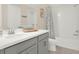 Stylish bathroom featuring gray vanity, framed mirror, and a shower-tub combo with a patterned shower curtain at 565 Big Pine Ave, Minneola, FL 34715