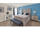 Well-lit bedroom features blue accent wall, decor, upholstered bed frame, and wood-look floors at 565 Big Pine Ave, Minneola, FL 34715