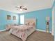 Bright bedroom featuring a tufted headboard bed, modern ceiling fan, and wood-look flooring at 565 Big Pine Ave, Minneola, FL 34715