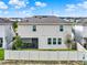 Back exterior view of two-story home, featuring a well-kept yard with a white fence and screened-in porch at 565 Big Pine Ave, Minneola, FL 34715