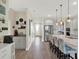 View of the open kitchen with a large island, stainless steel refrigerator, light gray cabinetry, and pendant lighting at 565 Big Pine Ave, Minneola, FL 34715