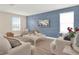 Living area featuring modern decor, a blue accent wall, and comfortable seating beneath a bright window at 565 Big Pine Ave, Minneola, FL 34715