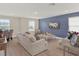 A spacious living room features modern furniture, a blue accent wall, and windows providing ample natural light at 565 Big Pine Ave, Minneola, FL 34715